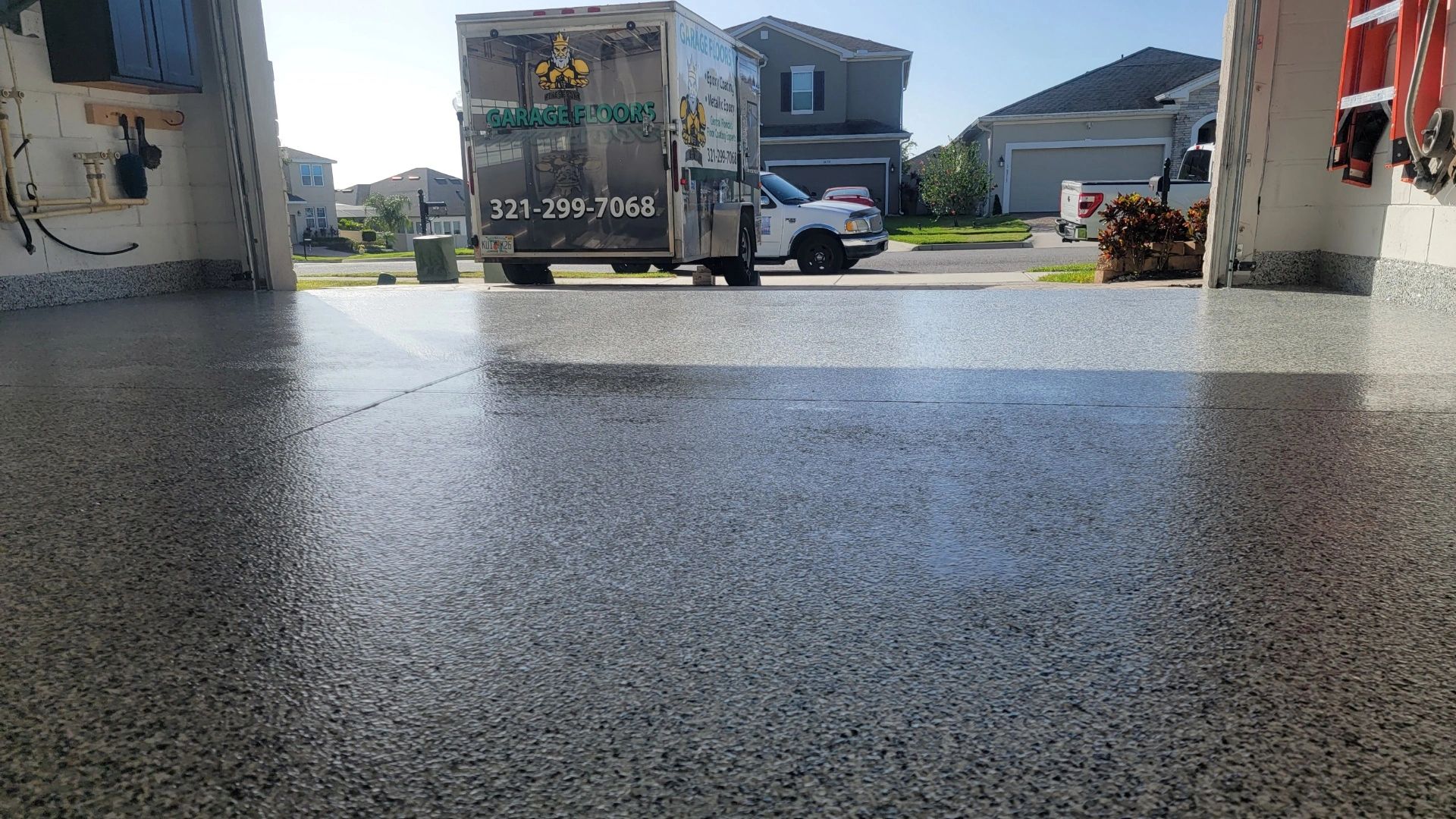 Reyes Epoxy service truck parked in driveway showing garage floor